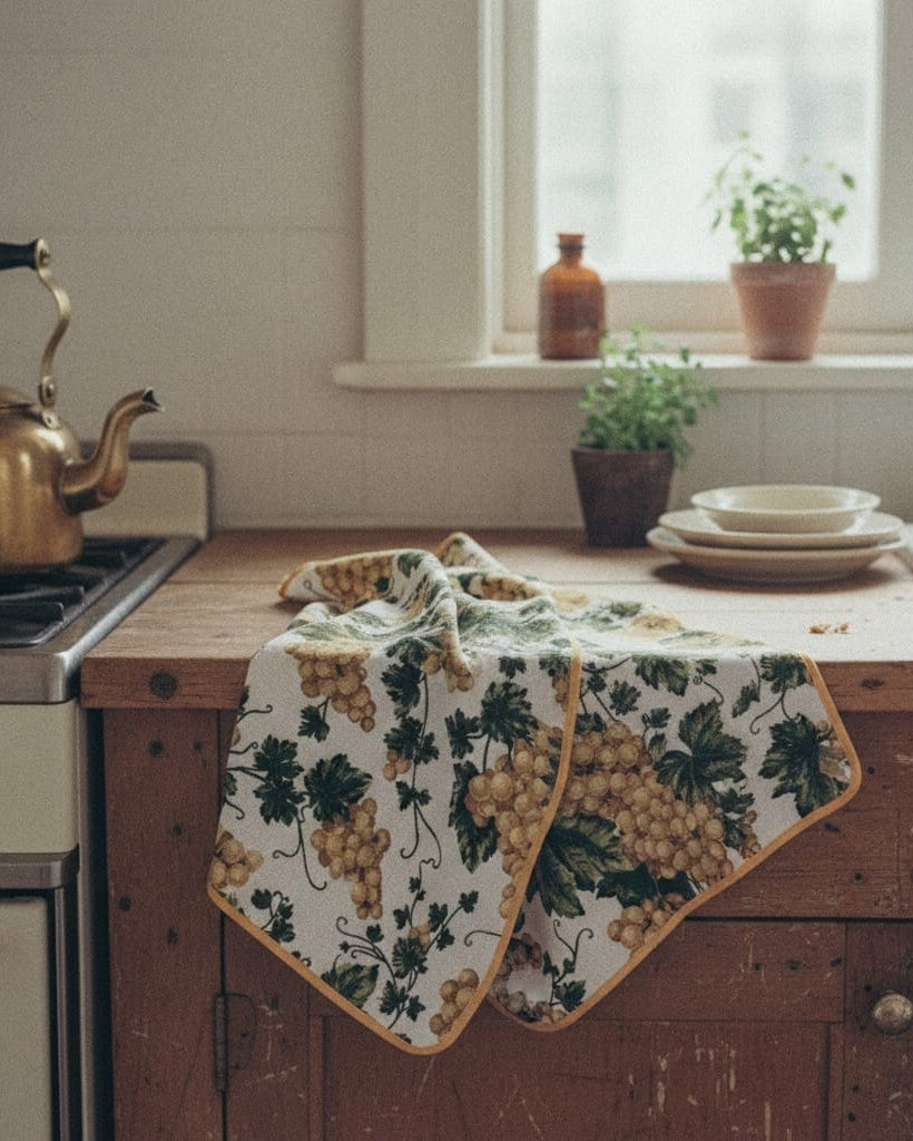 Vintage kitchen with wooden counter, floral towel, and decorative items.